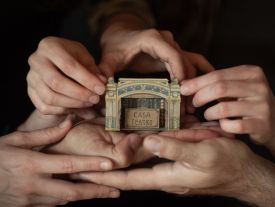 Image de mains encadrant la maison-théâtre