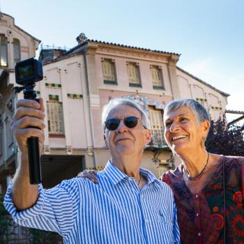 Pareja seniors amb la casa Barbey darrera fent-se autofoto